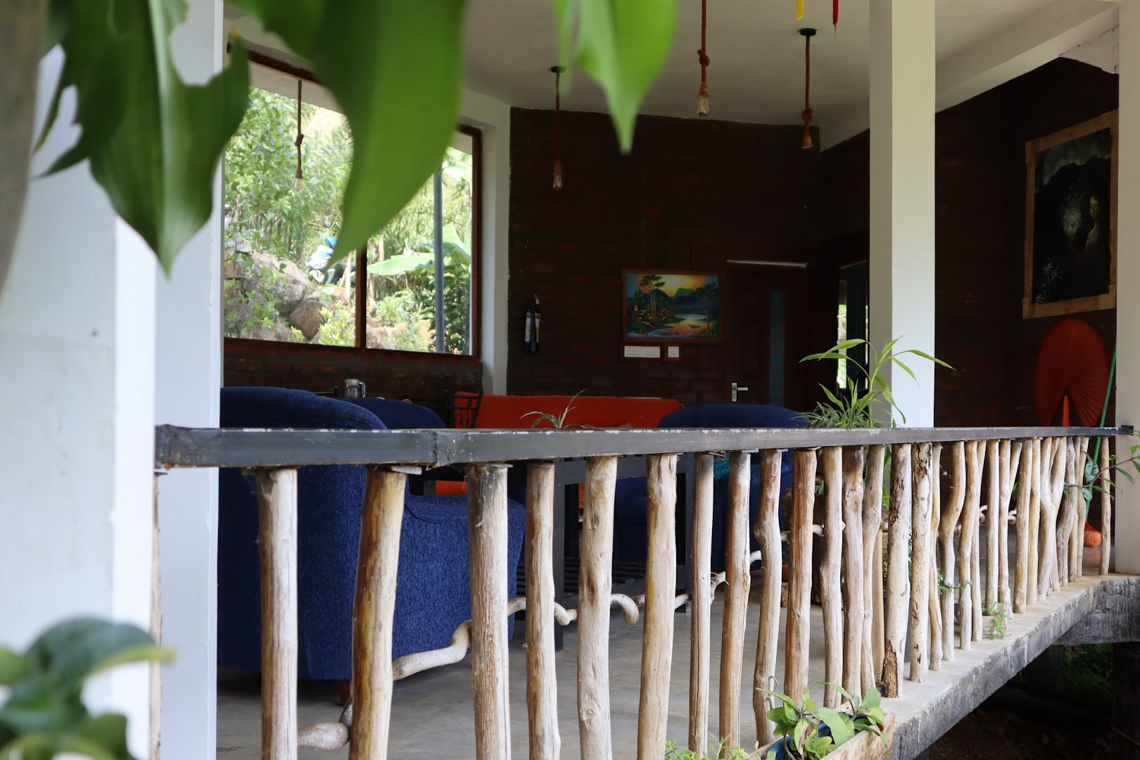 Open lounge with branch railings, brick walls, and blue seating